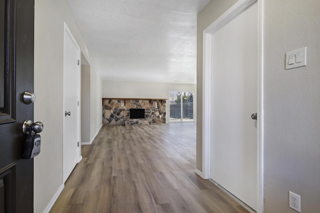 corridor featuring wood-type flooring and a textured ceiling