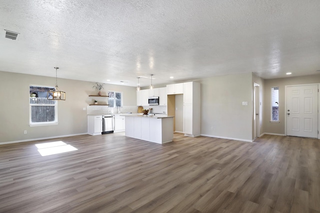 unfurnished living room featuring sink, dark hardwood / wood-style floors, and a textured ceiling