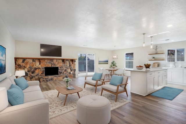 living room featuring sink, a fireplace, and light hardwood / wood-style floors