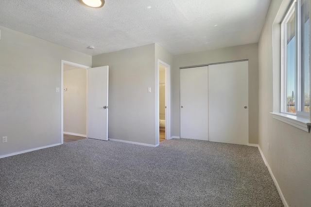 unfurnished bedroom with carpet flooring, a textured ceiling, and a closet