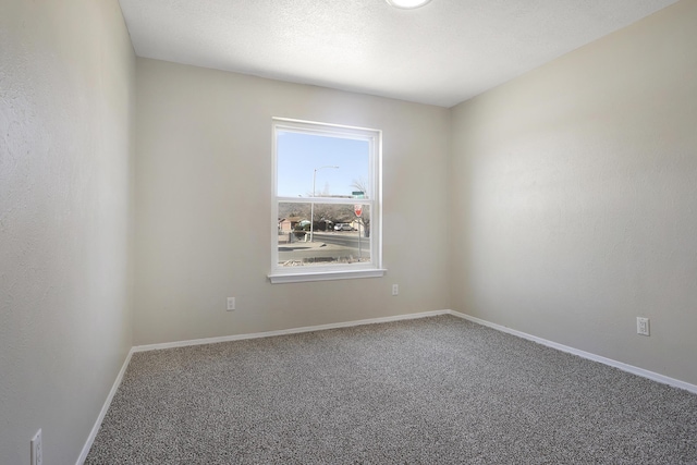 spare room featuring carpet flooring and a textured ceiling