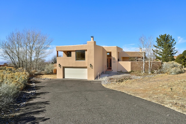 pueblo revival-style home with a garage