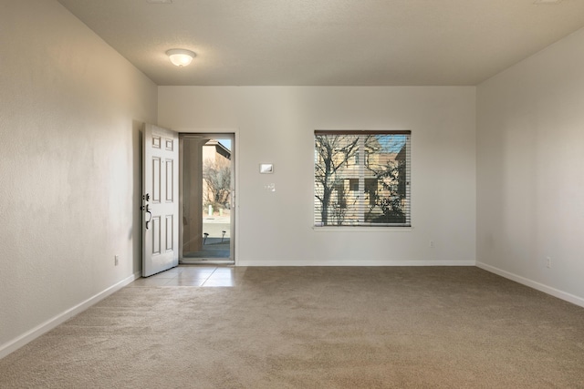 unfurnished room with light colored carpet and a textured ceiling