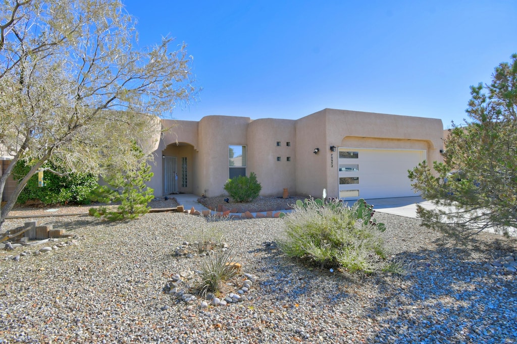 pueblo revival-style home with a garage