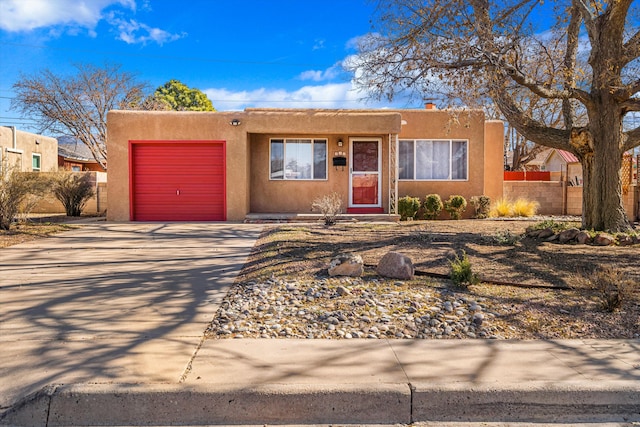 pueblo revival-style home with a garage