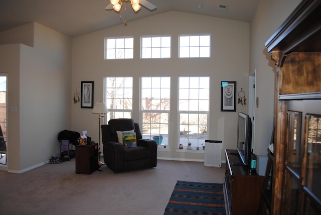 living area featuring plenty of natural light, high vaulted ceiling, ceiling fan, and carpet flooring