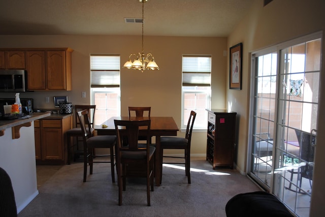 dining area with carpet floors and an inviting chandelier