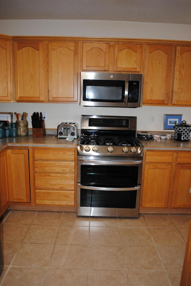 kitchen with stainless steel appliances and light tile patterned floors