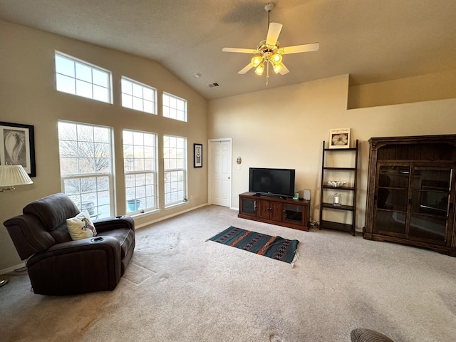 carpeted living room with ceiling fan and high vaulted ceiling