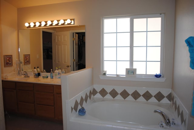 bathroom with vanity and tiled bath