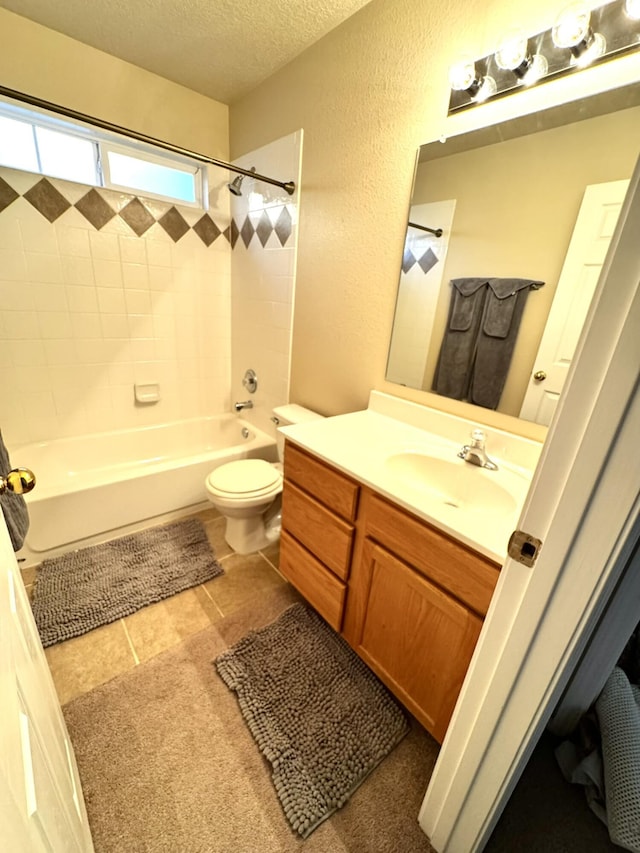 full bathroom with vanity, a textured ceiling, tile patterned floors, toilet, and tiled shower / bath