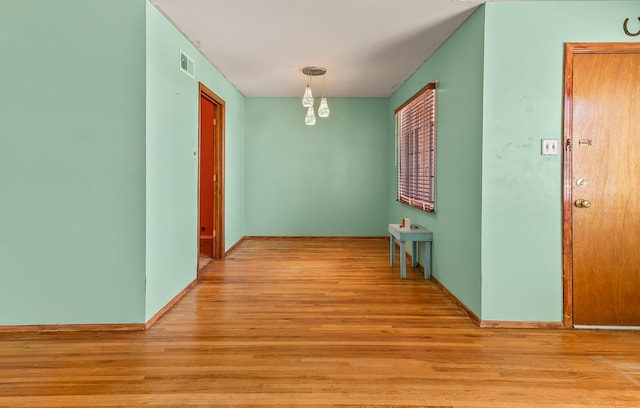 hallway with light hardwood / wood-style floors