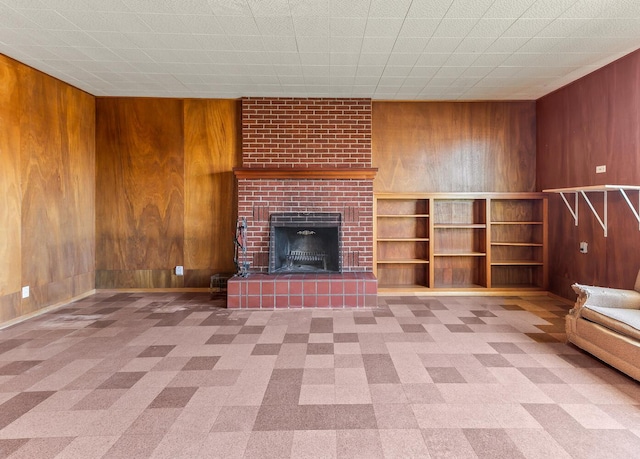 unfurnished living room featuring a fireplace and wooden walls