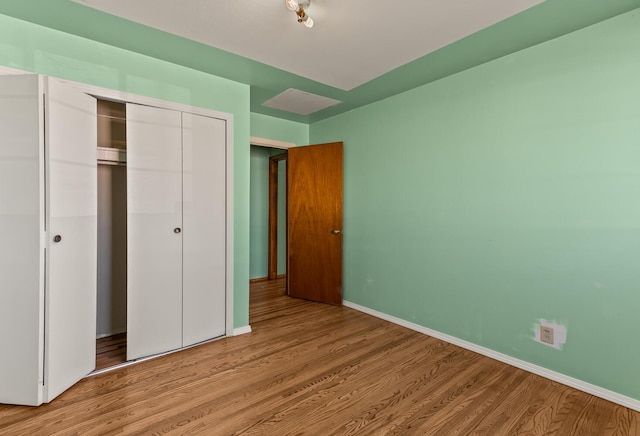 unfurnished bedroom with a closet and light wood-type flooring