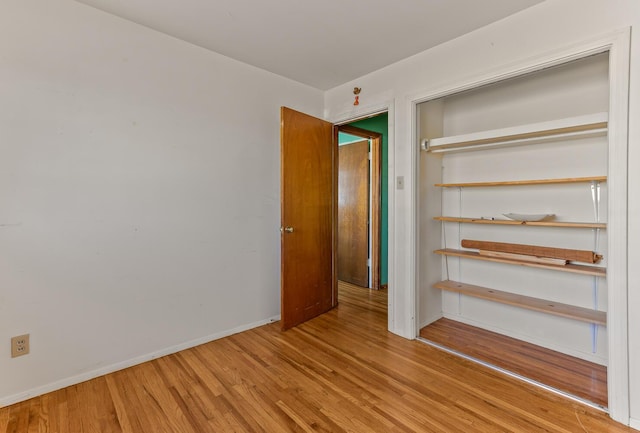 unfurnished bedroom with wood-type flooring and a closet