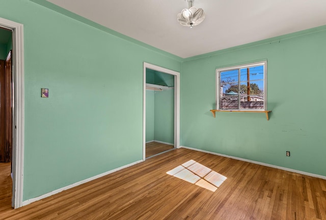 unfurnished bedroom featuring hardwood / wood-style floors and a closet