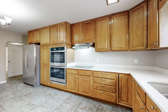 kitchen with an inviting chandelier, appliances with stainless steel finishes, and sink