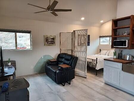 sitting room with ceiling fan, sink, and vaulted ceiling