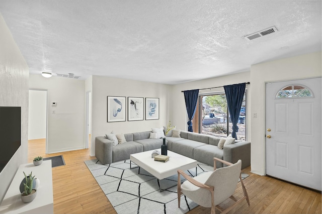 living room featuring a textured ceiling and light hardwood / wood-style flooring