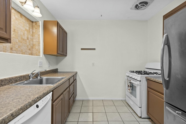 kitchen with white appliances, sink, and light tile patterned floors