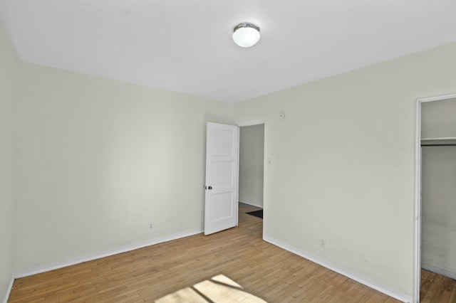 unfurnished bedroom featuring light hardwood / wood-style floors and a closet