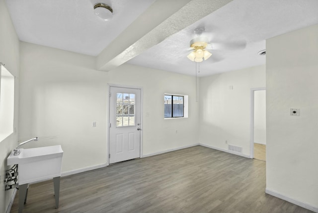 foyer entrance with hardwood / wood-style flooring, a textured ceiling, and ceiling fan