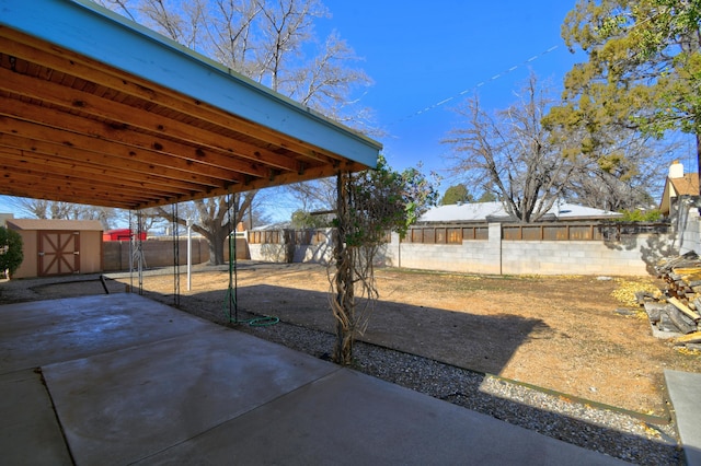 view of yard featuring a storage shed and a patio