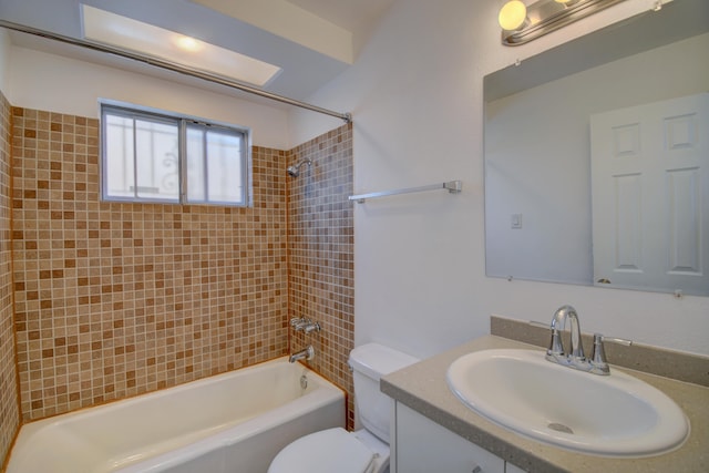 full bathroom featuring vanity, tiled shower / bath combo, and toilet