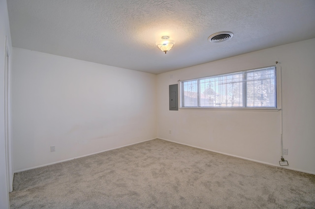 carpeted spare room featuring electric panel and a textured ceiling