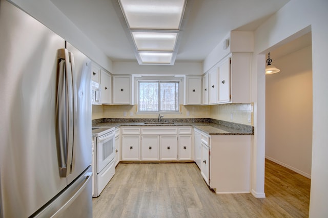 kitchen with sink, white appliances, and white cabinets