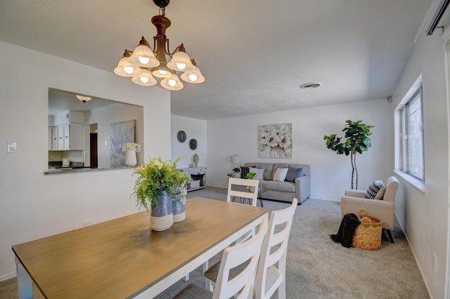 carpeted dining area with visible vents and an inviting chandelier