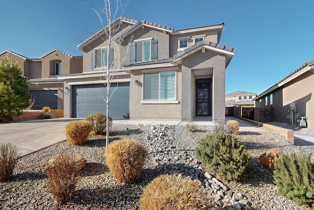 view of front of home featuring a garage, concrete driveway, and stucco siding