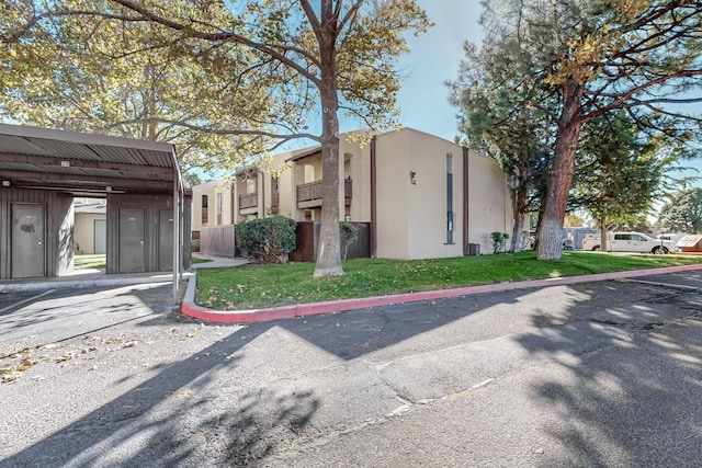 view of property exterior with a carport and a lawn