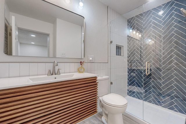 bathroom featuring vanity, tile walls, an enclosed shower, and toilet