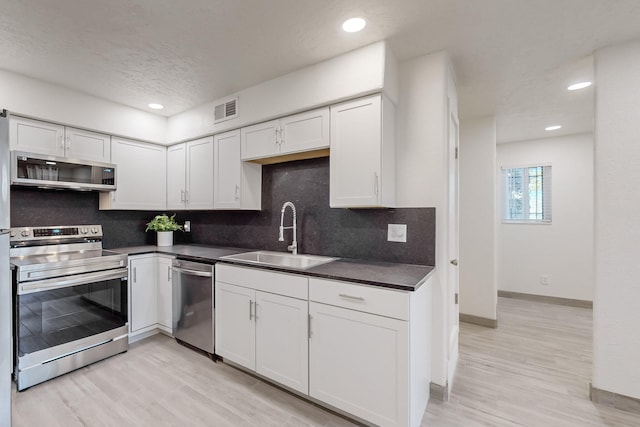 kitchen featuring white cabinetry, stainless steel appliances, sink, and tasteful backsplash