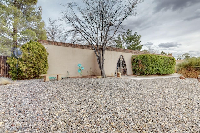 view of side of property featuring fence and stucco siding