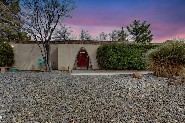 yard at dusk featuring a gate