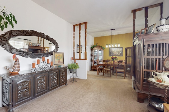 living area featuring light colored carpet and an inviting chandelier