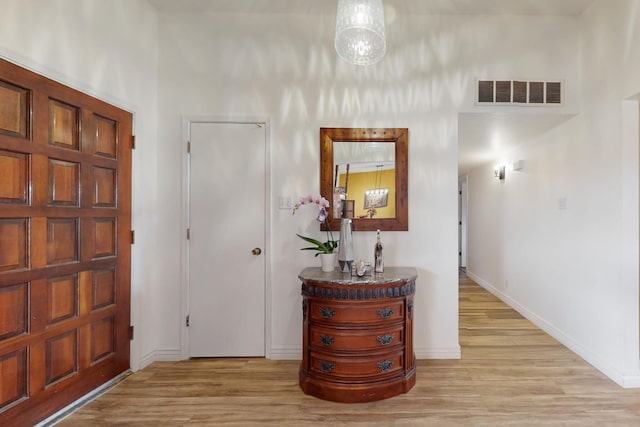 foyer entrance featuring light wood-type flooring, visible vents, and baseboards