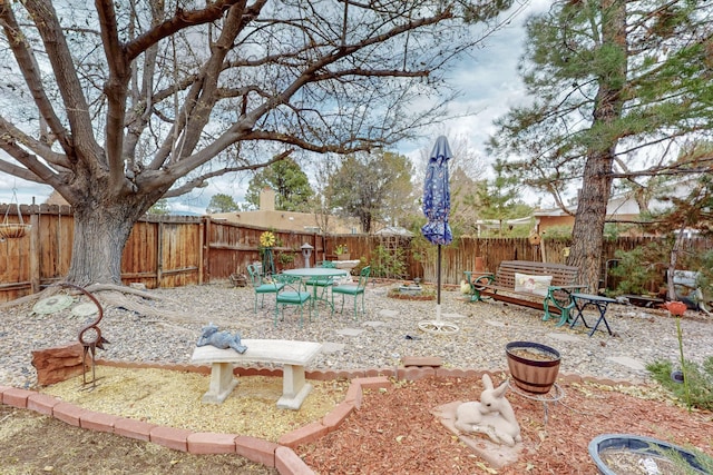 view of yard featuring outdoor dining area and a fenced backyard