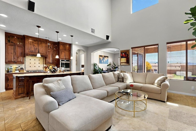 836 Mesa Roja Trl NE, Rio Rancho, NM 87144 - living room featuring arched walkways, recessed lighting, baseboards, and a high ceiling