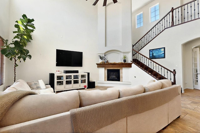 836 Mesa Roja Trl NE, Rio Rancho, NM 87144 - living area featuring a high ceiling, a glass covered fireplace, arched walkways, and stairway