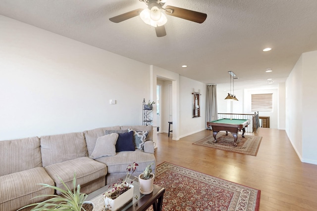 game room with ceiling fan, a textured ceiling, light wood-type flooring, and billiards