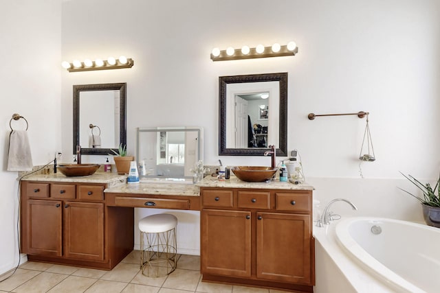 bathroom featuring tile patterned floors, vanity, and a washtub