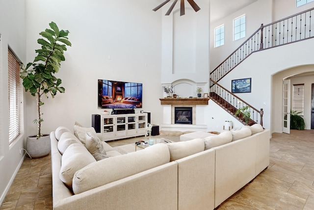 living room featuring a towering ceiling and ceiling fan