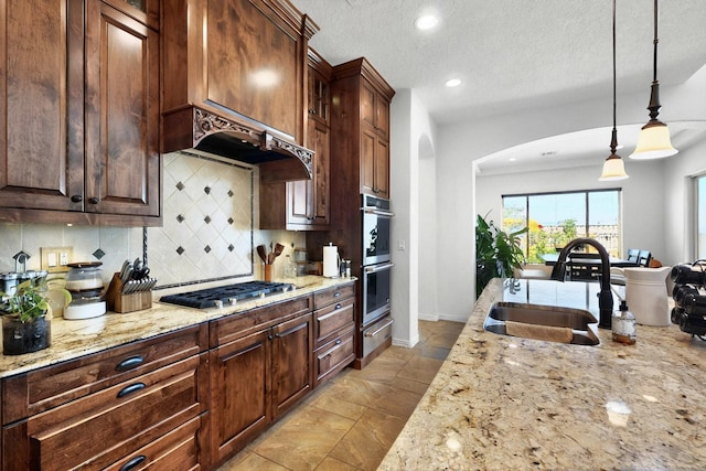836 Mesa Roja Trl NE, Rio Rancho, NM 87144 - kitchen with appliances with stainless steel finishes, a sink, arched walkways, a warming drawer, and decorative backsplash