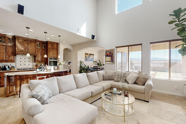 living room featuring light tile patterned floors and a towering ceiling