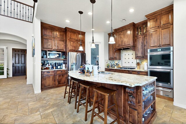 836 Mesa Roja Trl NE, Rio Rancho, NM 87144 - kitchen featuring appliances with stainless steel finishes, open shelves, a warming drawer, stone tile floors, and a sink