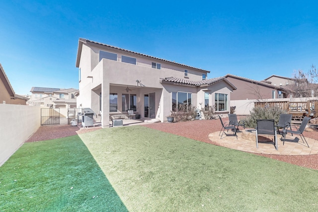 back of house with a lawn, ceiling fan, and a patio area