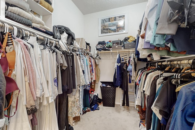 spacious closet featuring carpet flooring and vaulted ceiling